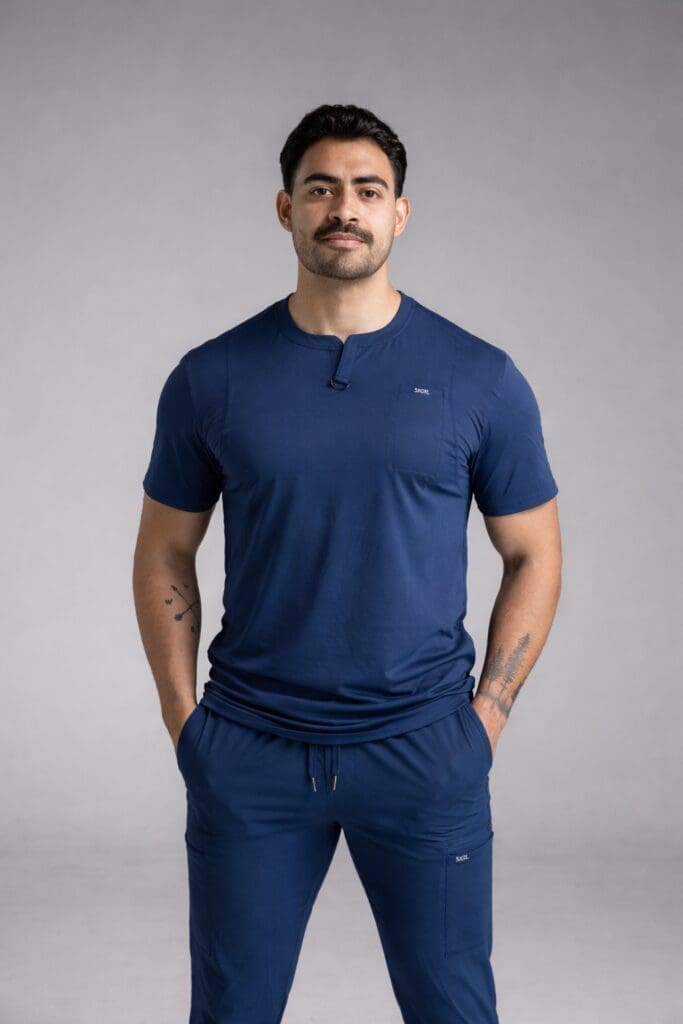 Person wearing navy scrubs, hands in pockets