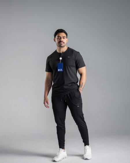 Man in black athletic wear with ID badge.